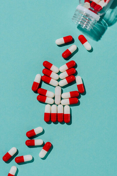 вид черепа из лекарственных таблеток на голубом столе
