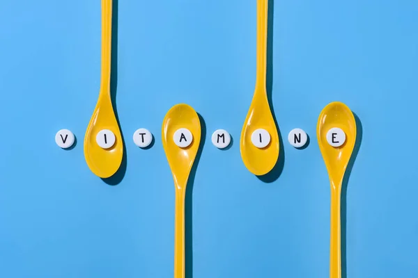 Top View Yellow Plastic Spoons Pills Vitamine Lettering Row Blue — Stock Photo, Image