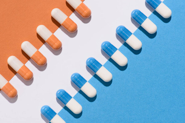 top view of blue and orange pills on colorful surface