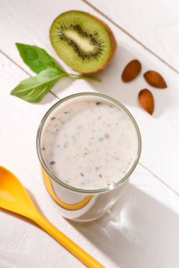 Beyaz ahşap masa üzerinde protein içeceği kivi ile yüksek açılı görünüş