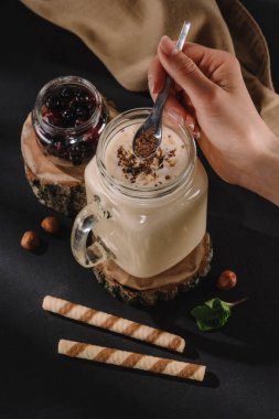 Çikolata talaşı milkshake, nane, tatlı çörek ve kuş üzümü masanın üzerine koyarak el kırpılmış atış 