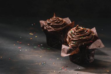 Buttercream sır ve masanın üzerine yayılan şeker ile lezzetli çikolata cupcakes