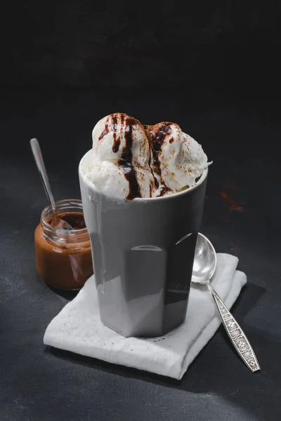 delicious ice cream in cup and jar with chocolate on table