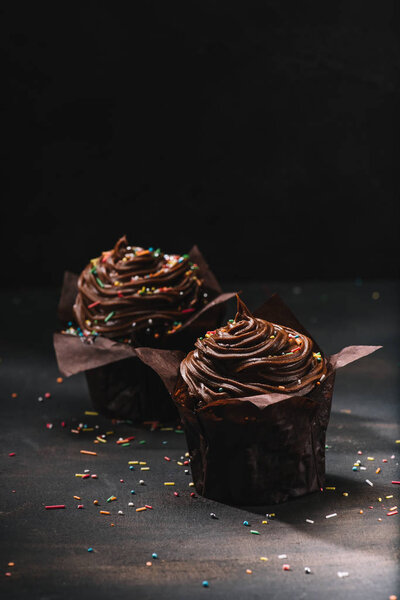 Appetizing chocolate cupcakes with buttercream glaze on table