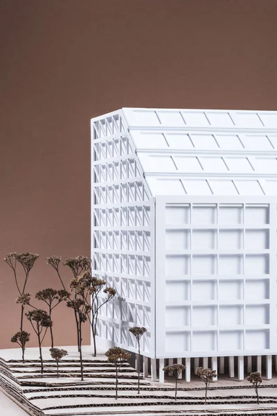 Крупним Планом Модель Білого Будівництва Мініатюрними Деревами Коричневому Тлі — Безкоштовне стокове фото