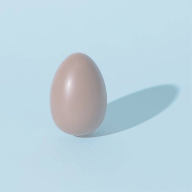chocolate egg on blue pale background with shadow clipart