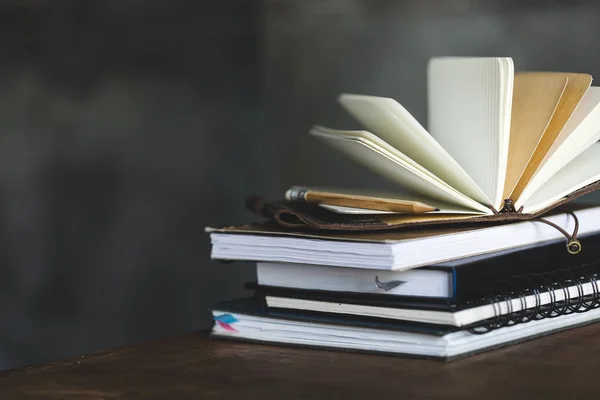 Stack of books and diaries on dark grey with copy space — Stock Photo