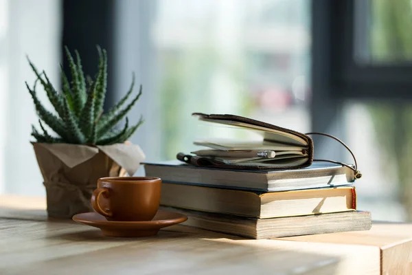 Nahaufnahme von Büchern, Notizbuch mit Bleistift und Kaffeetasse auf Holztisch — Stockfoto