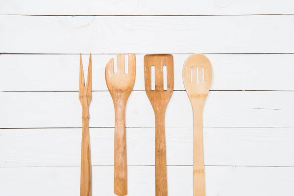 Top view of various wooden spatulas on white tabletop — Stock Photo