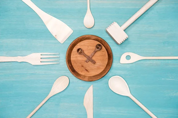 Vista dall'alto di vari utensili da cucina in legno con simbolo dell'orologio sul piatto — Foto stock