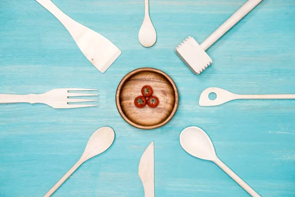 Vista dall'alto di utensili da cucina in legno con pomodorini ciliegini sul piatto — Foto stock