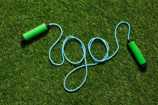 Top view of skipping rope on the grass in form of word go — Stock Photo