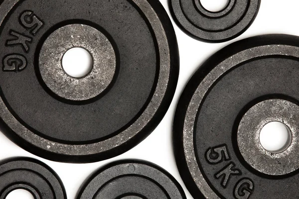 Vue rapprochée de différentes plaques de poids pour la musculation isolées sur blanc — Photo de stock