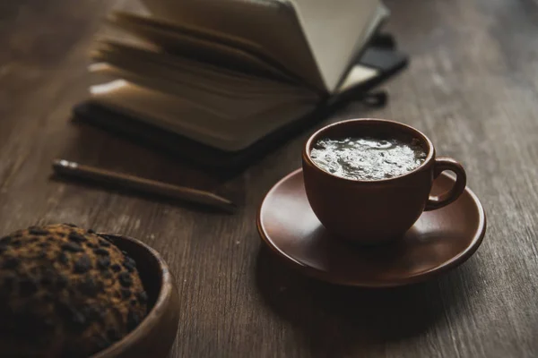 Cup of coffee and notebook — Stock Photo