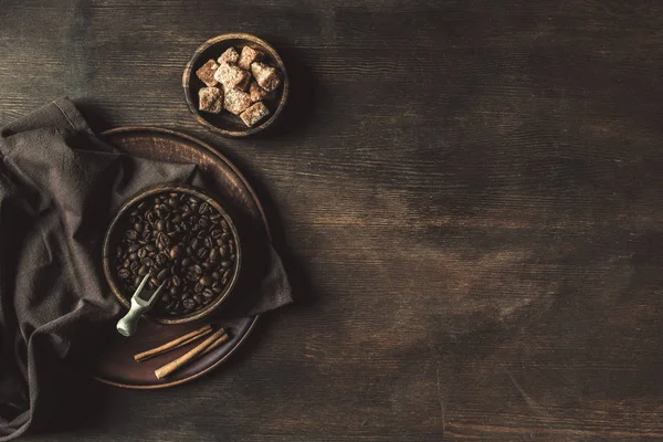 Kaffeebohnen und brauner Zucker auf der Tischplatte — Stockfoto