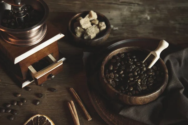 Kaffeemühle mit Bohnen auf Holztischplatte — Stockfoto