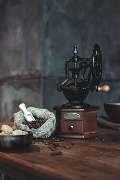 Molinillo de café vintage con frijoles en la mesa — Stock Photo