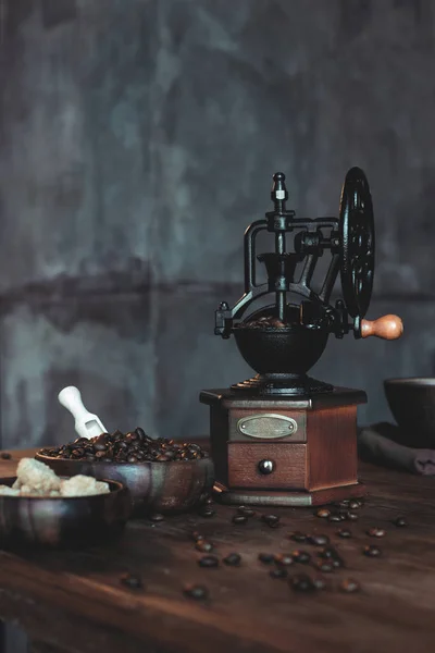 Moedor de café vintage com grãos na mesa — Fotografia de Stock