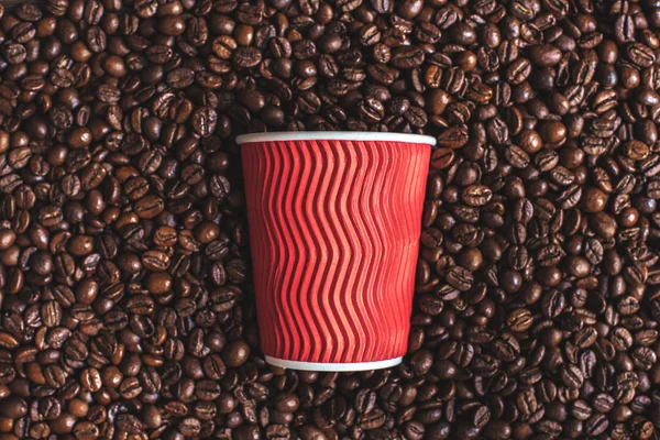 Plastikbecher auf gerösteten Kaffeebohnen — Stockfoto