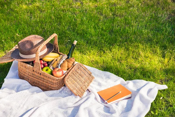 Cesta de picnic y cuaderno con lápiz - foto de stock