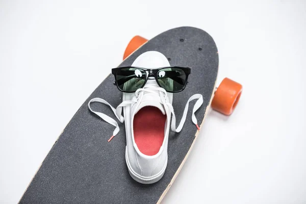 Sapatilha e óculos de sol no skate — Fotografia de Stock