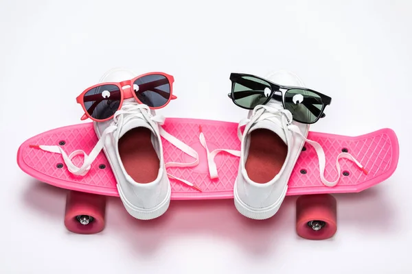 Кроссовки и солнечные очки на скейтборде — стоковое фото