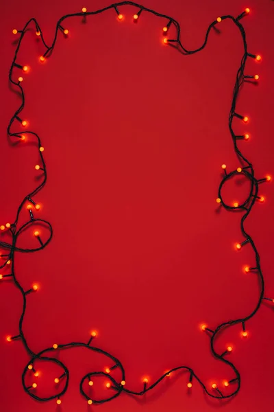 Vue de dessus des lumières de Noël isolées sur rouge — Photo de stock