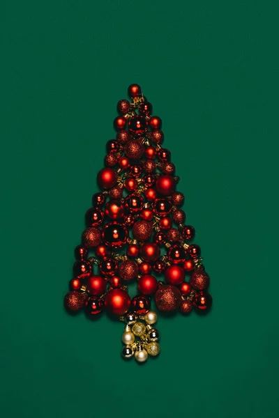 Top view of christmas toys arranged into christmas tree isolated on green — Stock Photo