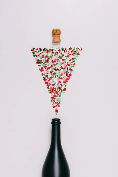 Vista superior de la botella y corcho arreglado con confeti colorido en el árbol de Navidad aislado en blanco — Stock Photo