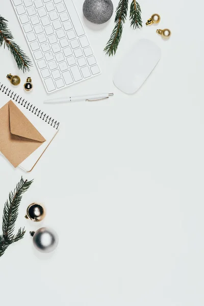 Piso con suministros de oficina arreglados, juguetes de Navidad y ramas aisladas en blanco - foto de stock