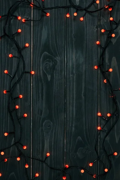 Вид зверху на різдвяні вогні на темній дерев'яній стільниці — стокове фото
