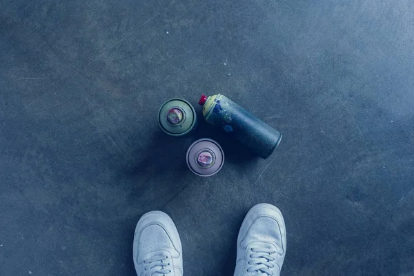 Partial view of man standing near aerosol paint in cans — Stock Photo