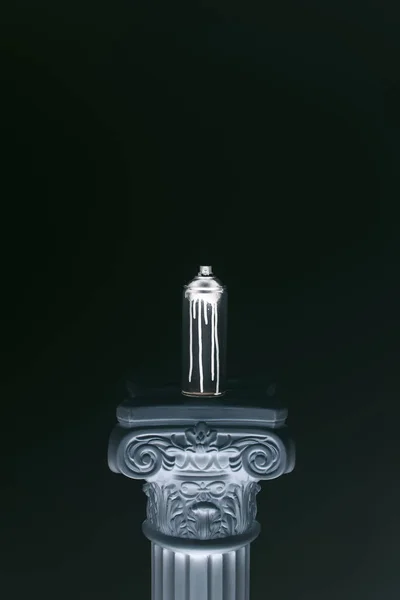 Крупним планом розпилювальна фарба в банці, що стоїть на колонці ізольовано на чорному — стокове фото