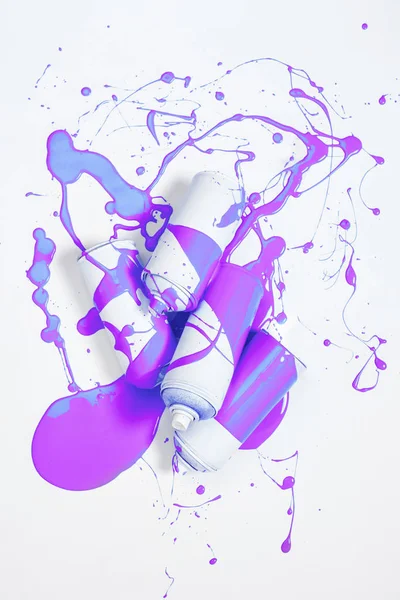 Крупним планом розпилювальна фарба в банках, покритих фіолетовою фарбою, ізольовані на білому — стокове фото
