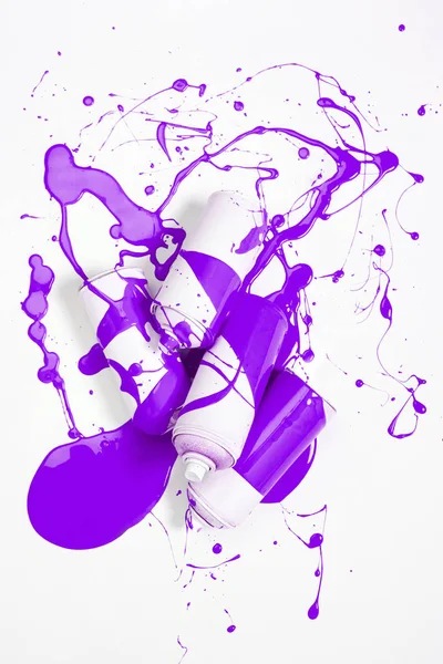 Крупним планом розпилювальна фарба в банках, покритих фіолетовою фарбою, ізольовані на білому — стокове фото