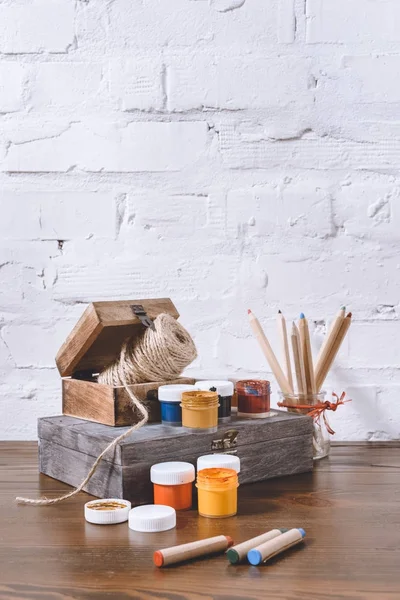 Poster paints and wooden boxes on table — Stock Photo