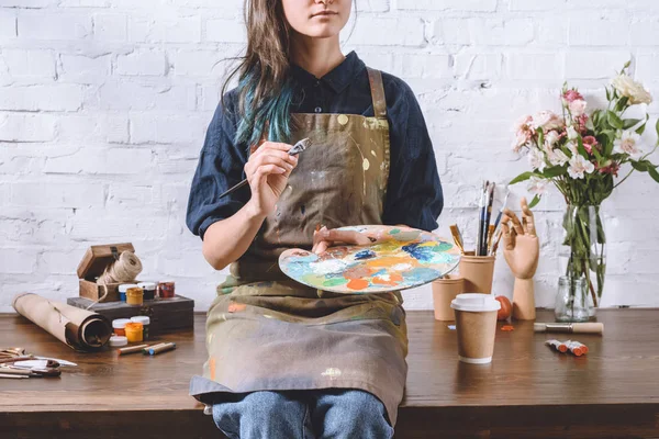 Cropped image of artist holding palette and brush — Stock Photo