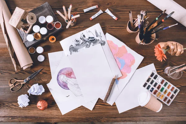 Top view of designer workplace with sketches and paints — Stock Photo