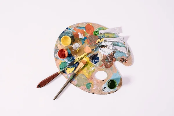 Vista superior de la paleta con pinturas de colores aislados en gris - foto de stock