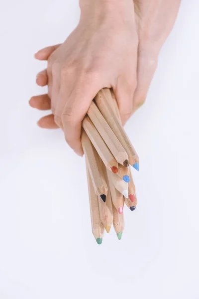 Tiro recortado de mãos femininas segurando lápis de cera coloridos isolados em branco — Fotografia de Stock