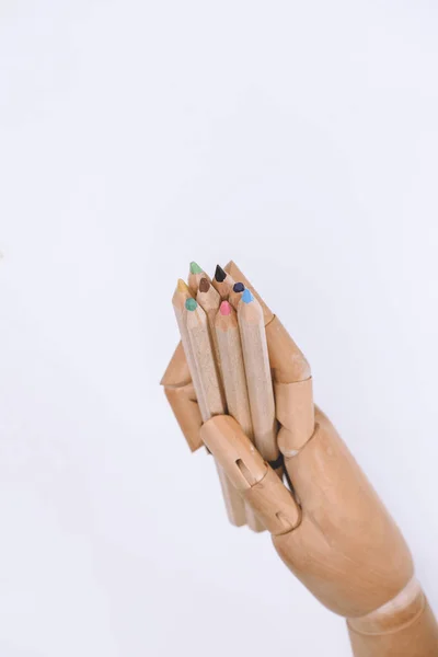Крупный план манекена с цветными карандашами, изолированными на белом — стоковое фото