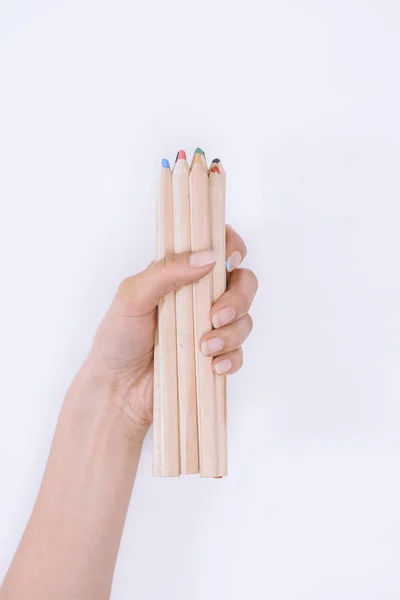 Close-up partial view of human hand holding crayons isolated on white — Stock Photo