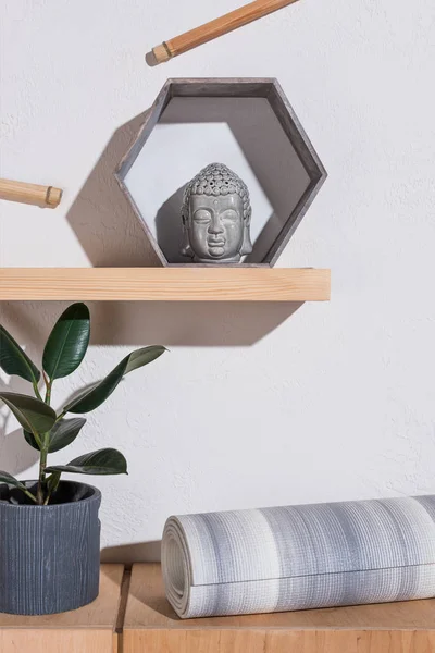 Tapete de ioga sob escultura de cabeça de buddha no quadro — Fotografia de Stock
