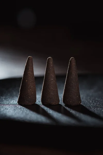 Three incense sticks on dark surface — Stock Photo