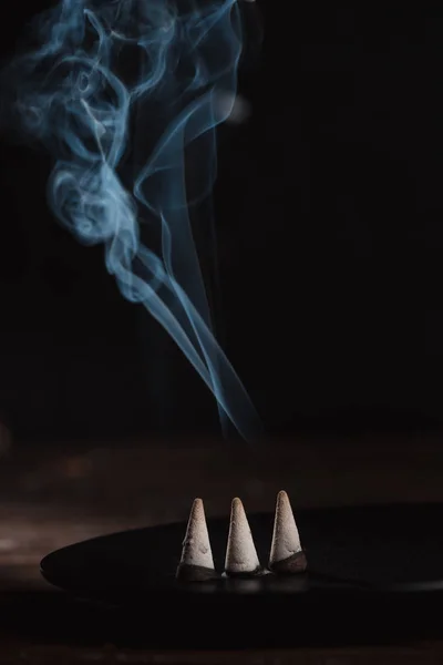 Three burning incense sticks with smoke on table — Stock Photo