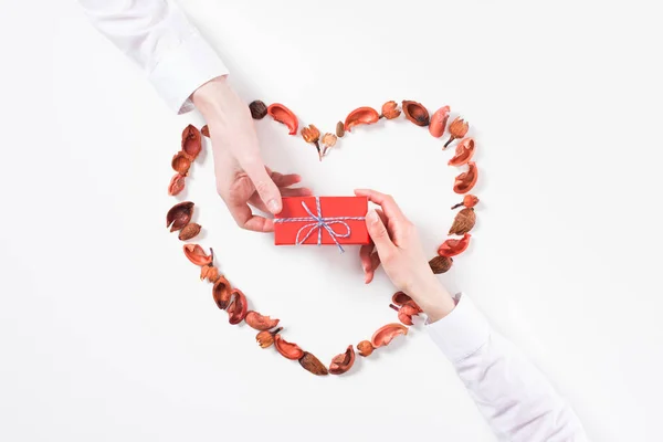 Image recadrée de petit ami présentant cadeau petite amie sur la Saint Valentin isolé sur blanc — Photo de stock