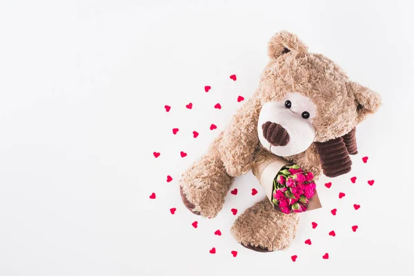 Vista superior del osito de peluche con ramo de rosas rosadas aisladas en blanco, concepto de día de San Valentín - foto de stock