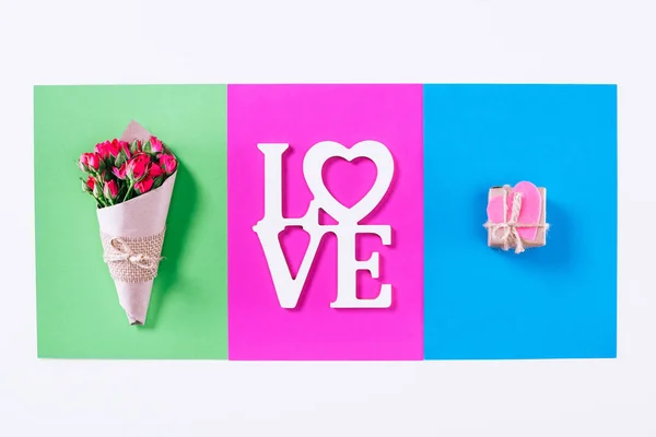 Draufsicht auf Blumenstrauß und Valentinstag mit Wort Liebe isoliert auf Weiß — Stockfoto