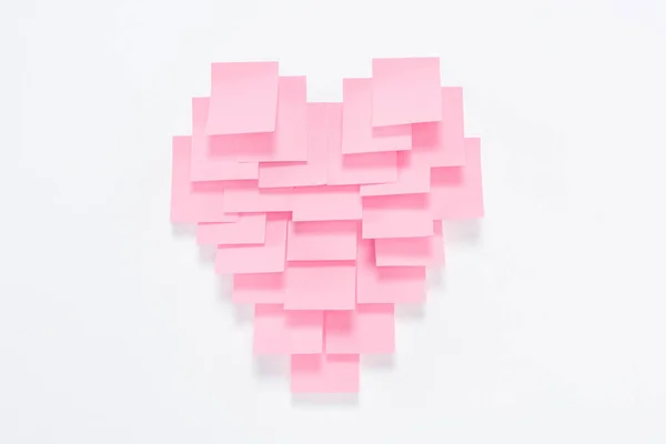 Pink paper pieces in shape of heart on white, valentines day concept — Stock Photo