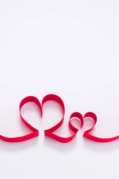 Dos corazones rojos de la cinta en el concepto blanco, día de San Valentín - foto de stock